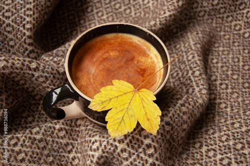 Cozy autumn coffee with leaves and a blanket