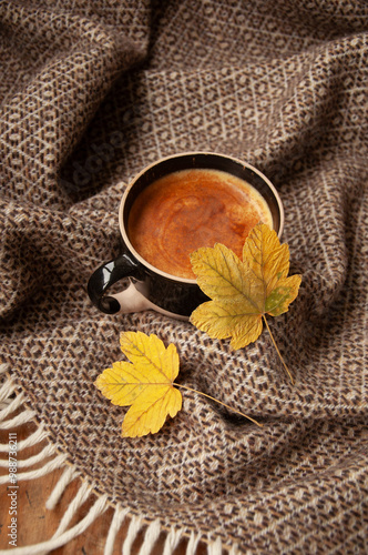 Cozy autumn coffee with leaves and a blanket