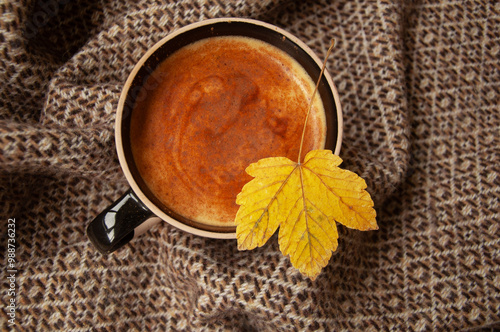 Cozy autumn coffee with leaves and a blanket