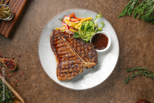 Quadro su tela Portion of grilled beef t bone steak with salad