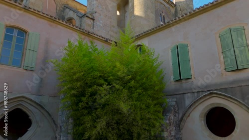 Aerial establishing shot of a beautiful French Abbey courtyard and church bells photo