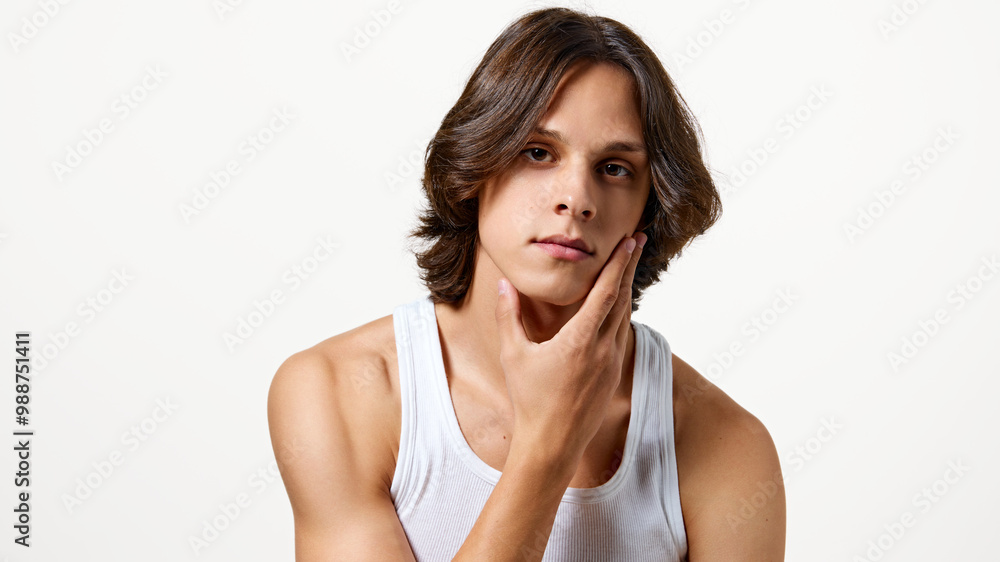 Portrait of young attractive man touching his soft skin on chin after shaving against white studio background. Concept of natural beauty, fashion, cosmetic product, male health. Ad Portrait of young attractive man touching his soft skin on chin after shaving against white studio background. Concept of natural beauty, fashion, cosmetic product, male health. Ad