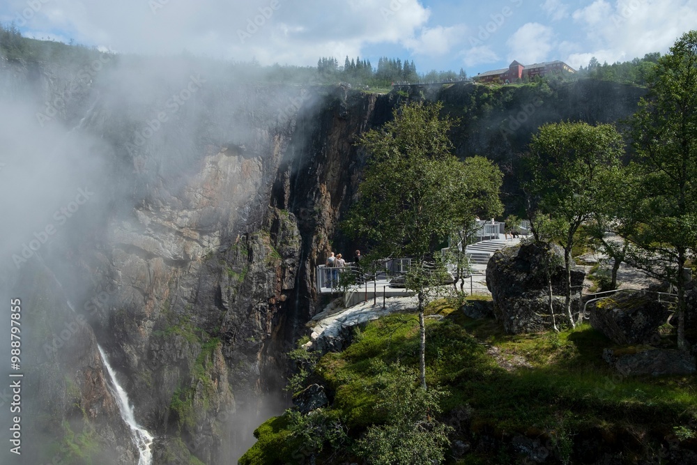 Tourists at a scenic lookout in a misty mountain landscape. Tourists at a scenic lookout in a misty mountain landscape.