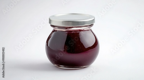 A small, elegant glass jar of plum jam, sealed with a modern metal lid, displayed on a white background, representing high-quality gourmet food packaging.