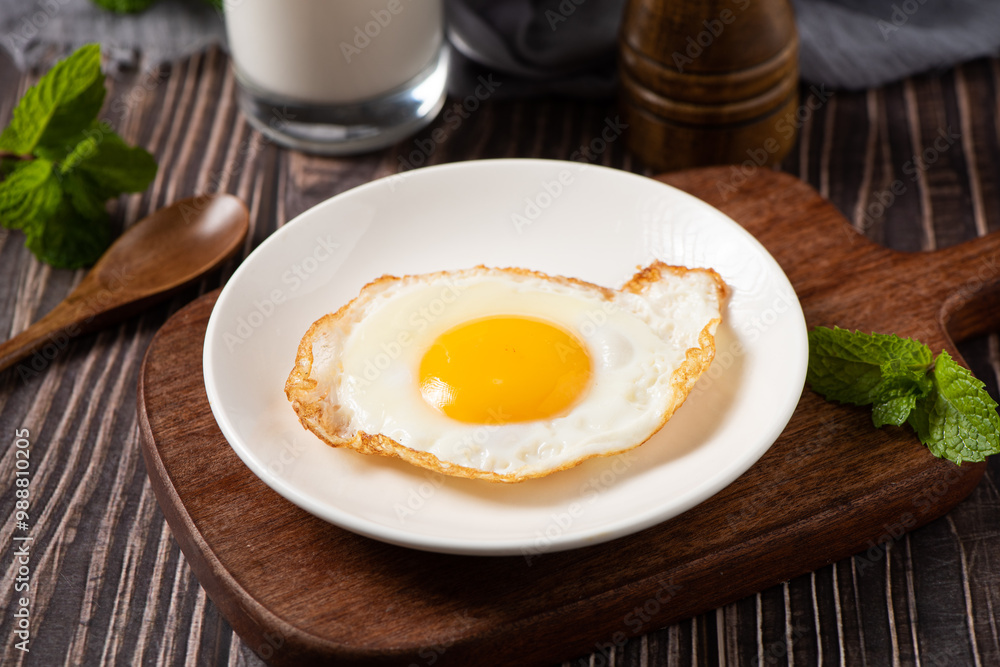 fried egg in a white plate on table. fried egg in a white plate on table.