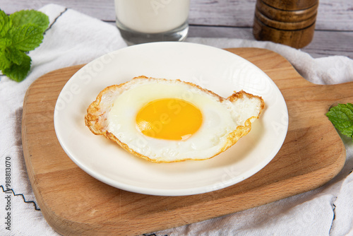 fried egg in a white plate on table. photo