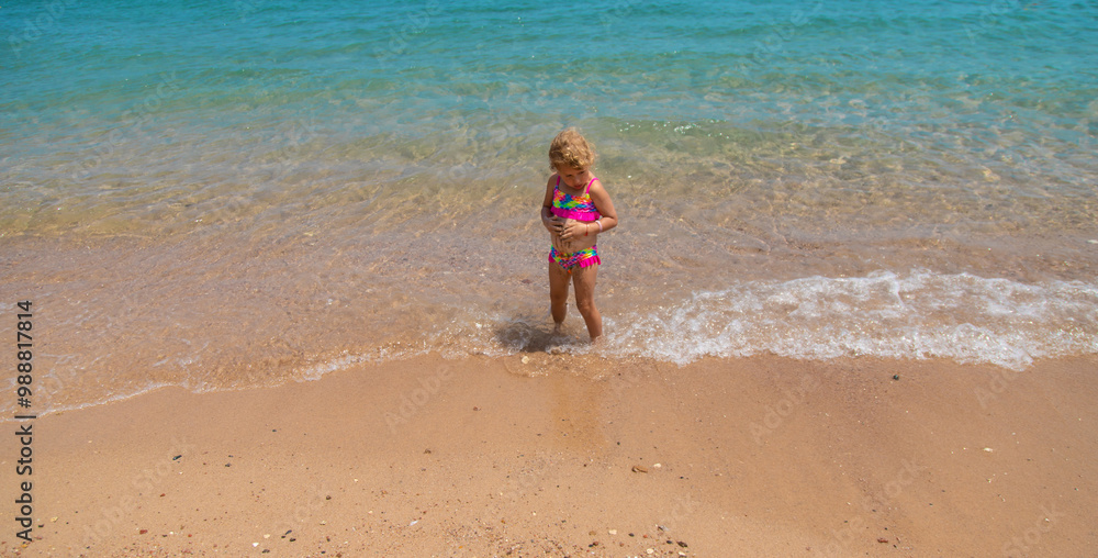 Child playing with sand on the beach at sea. Selective focus. Child playing with sand on the beach at sea. Selective focus.