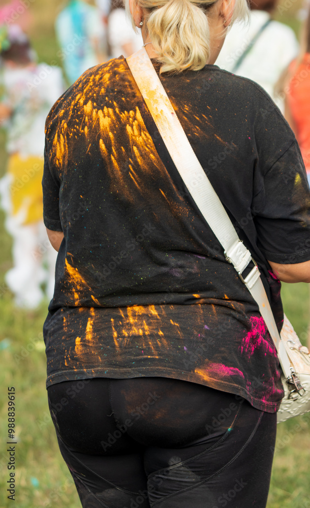 Obraz premium A woman wearing a black shirt with orange and white splatters on it