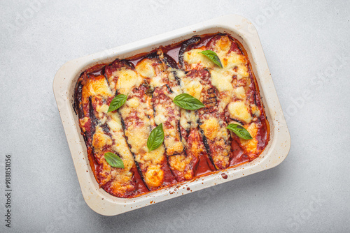 Obraz na plátne Eggplant parmigiana di melanzane freshly baked and decorated with basil leaves, resting in a baking pan