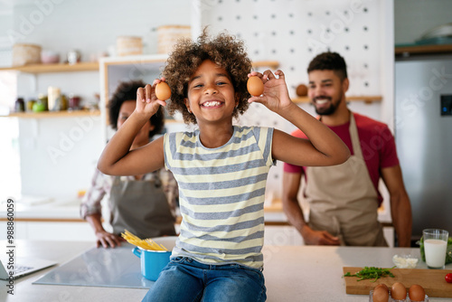 Happy african american family preparing healthy food in kitchen, having fun together on weekend photo