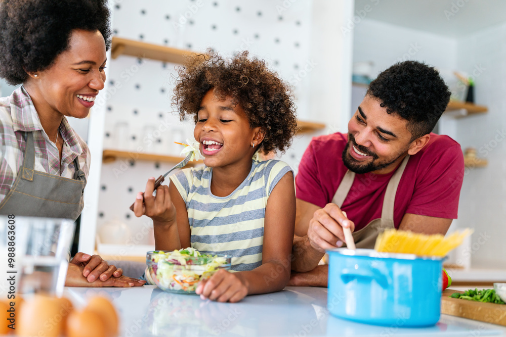 Happy african american family preparing healthy food in kitchen, having fun together on weekend Happy african american family preparing healthy food in kitchen, having fun together on weekend
