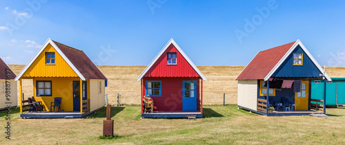 Obraz na płótnie Panorama of blue, yellow and red wooden cottages in Termunterzijl, Netherlands w salonie