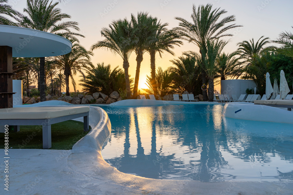 Fototapeta premium Relaxing pool surrounded by greenery and a beautiful sunset.