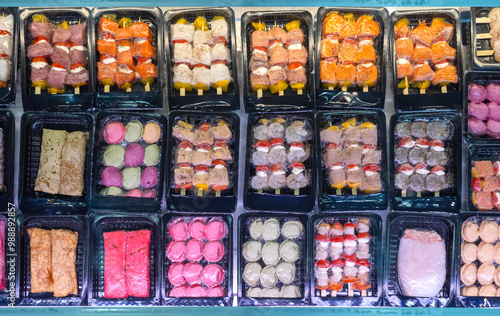 Fish snacks in vacuum packaging. Seafood store counter top view. Vacuuming food to avoid loss of vitamins - concept. Fish skewers and cutlets in vacuum packaging. Fresh seafood. Maluski, squid
