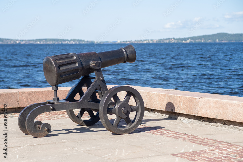 A historical cannon is placed against the scenic backdrop of Lake Onega, highlighting Petrozavodsk's rich history and cultural significance A historical cannon is placed against the scenic backdrop of Lake Onega, highlighting Petrozavodsk's rich history and cultural significance