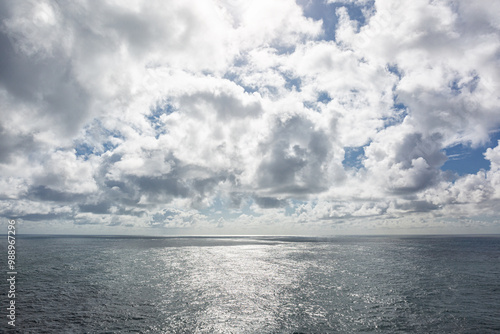 Bewolkte lucht met spiegelend zonlicht op de golven van de zee photo