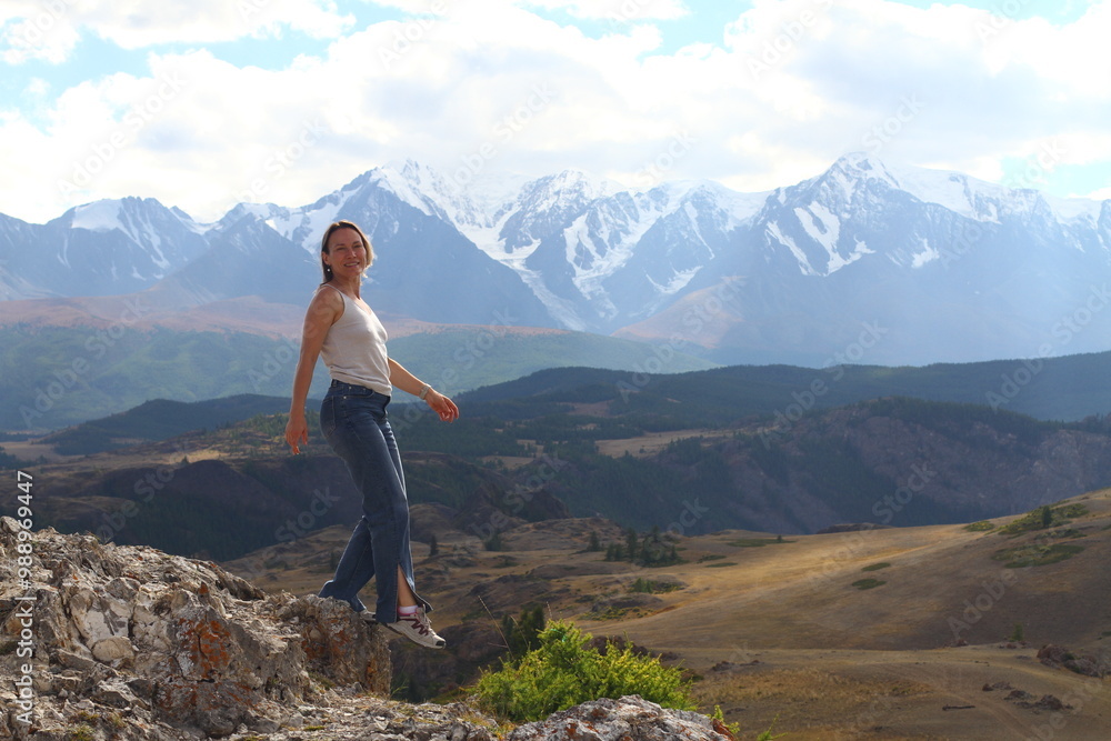 Obraz premium Hiker woman on top Aktash Altai mountains. Scenic view and snowy tops on background.