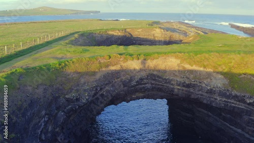 Bridges of Ross at sunrise, with a striking human shadow crossing the natural bridge. Co Clare photo