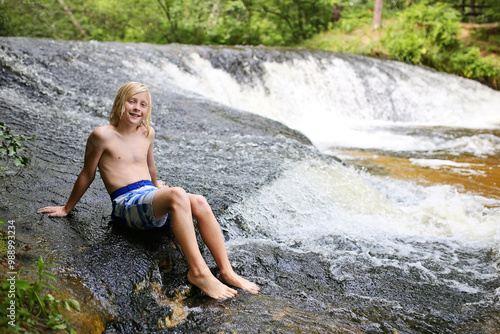 Happy Boy Child Swimming in Waterfall on Summer Day