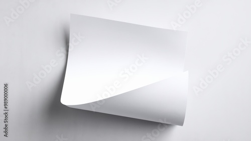 A photo of a blank white sheet of paper, possibly A4 size, placed against a plain white background. The paper is slightly curled at the bottom, giving it a three-dimensional appearance.