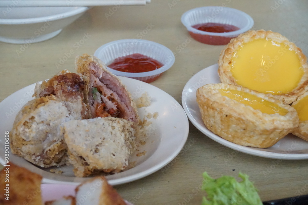 Traditional Chinese dim sum in metal bowl on wooden table. A lot of different kinds of food and drinks on the table
