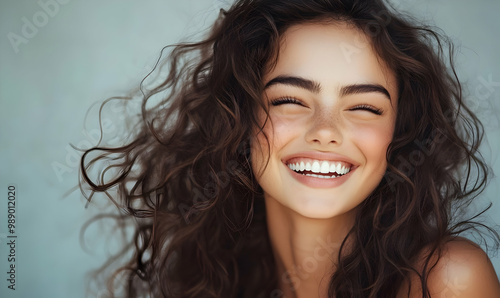 Beautiful laughing brunette model girl with long curly hair