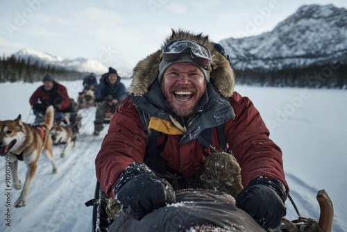 An exhilarated man leads a team of dogs through a snowy landscape, encapsulating the thrill and teamwork of traditional dog sledding in winter wonderland.