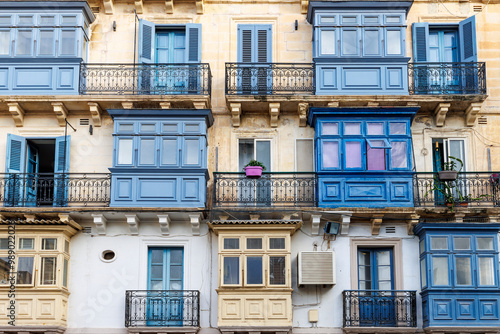 Facade of the old houses with characteristic blue windows and doors  in the historic center of Valletta, Malta, Europe