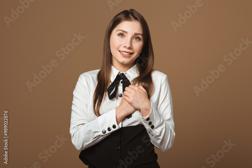 Portrait of a Lovely, Charming Young Woman Holding Palms Near Her Heart in a Gesture of Gratitude and Love. Concept of Appreciation, Love, and Heartfelt Emotions