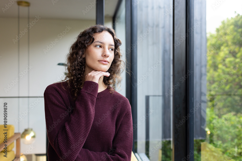 Looking out window, woman in cozy sweater enjoying peaceful moment indoors Looking out window, woman in cozy sweater enjoying peaceful moment indoors