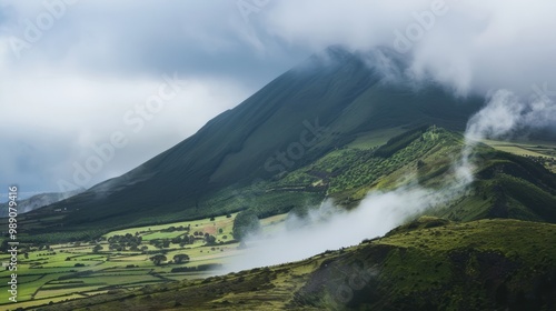 Foggy mountain with green hills and fields below. Misty landscape and nature concept.