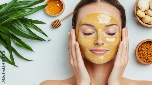 Female model with glowing skin applying a honeybased face mask, with natural ingredients in the background, honey skincare, natural beauty photo