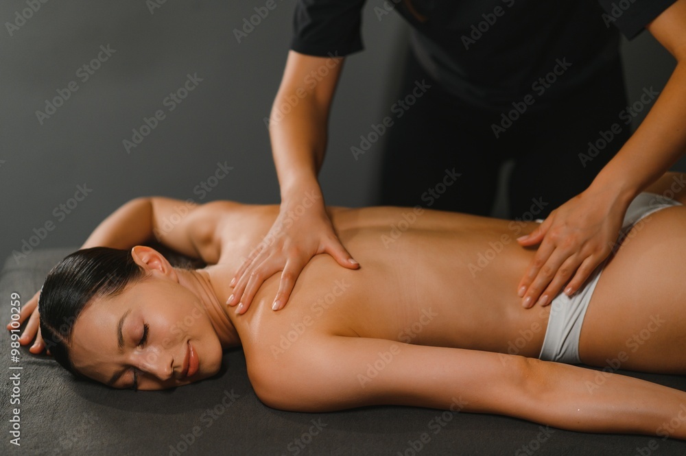 Fototapeta premium Spa woman. Female enjoying relaxing back massage in cosmetology spa centrer
