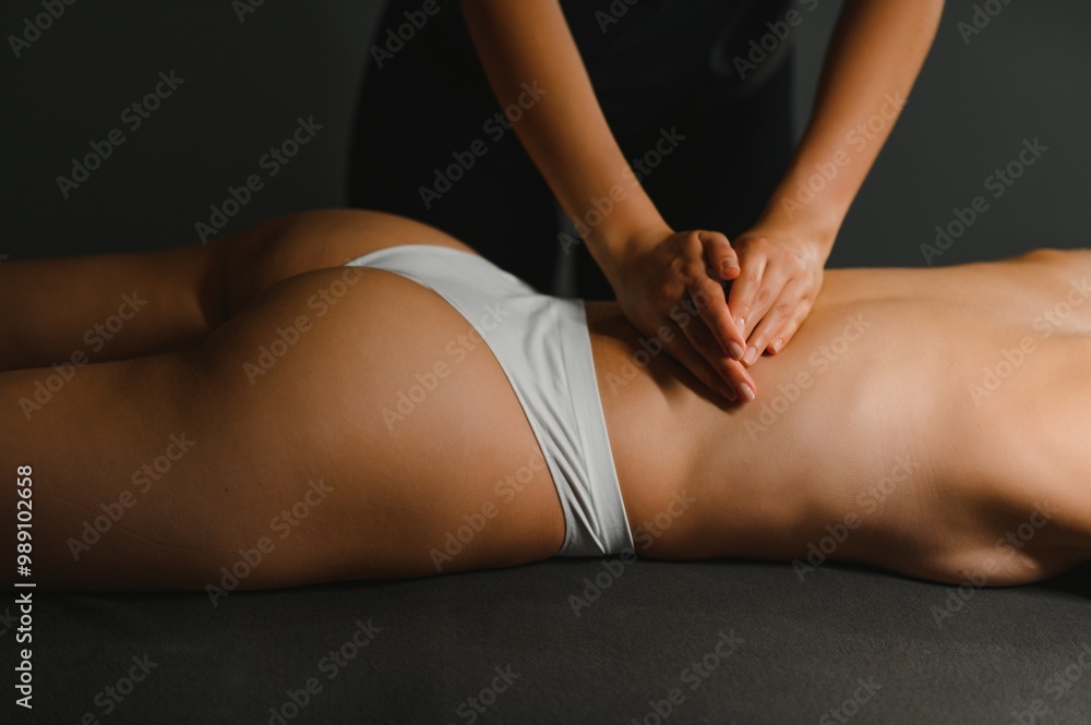 Masseur doing massage on woman back in the spa salon Masseur doing massage on woman back in the spa salon