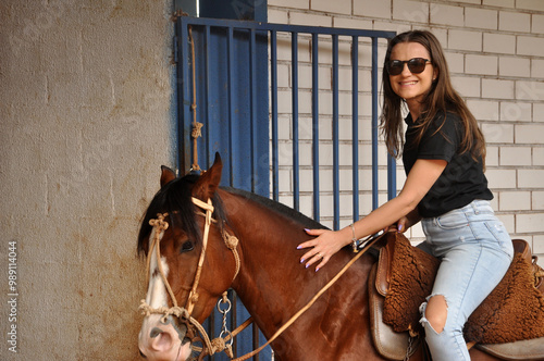 beldade vaqueira sorrindo anda de cavalo  photo