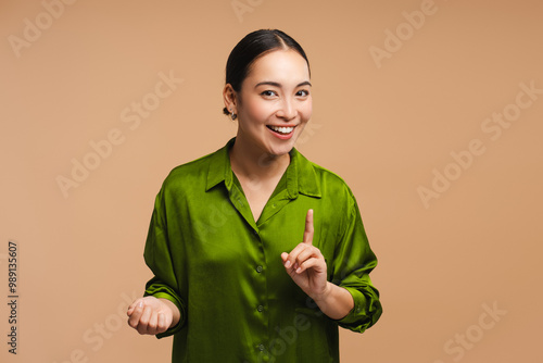 Obraz na plátně Asian woman influencer recording video having an idea is pointing up with finger