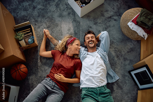 Quadro su tela Above view of happy couple relaxing on carpet after moving into new house