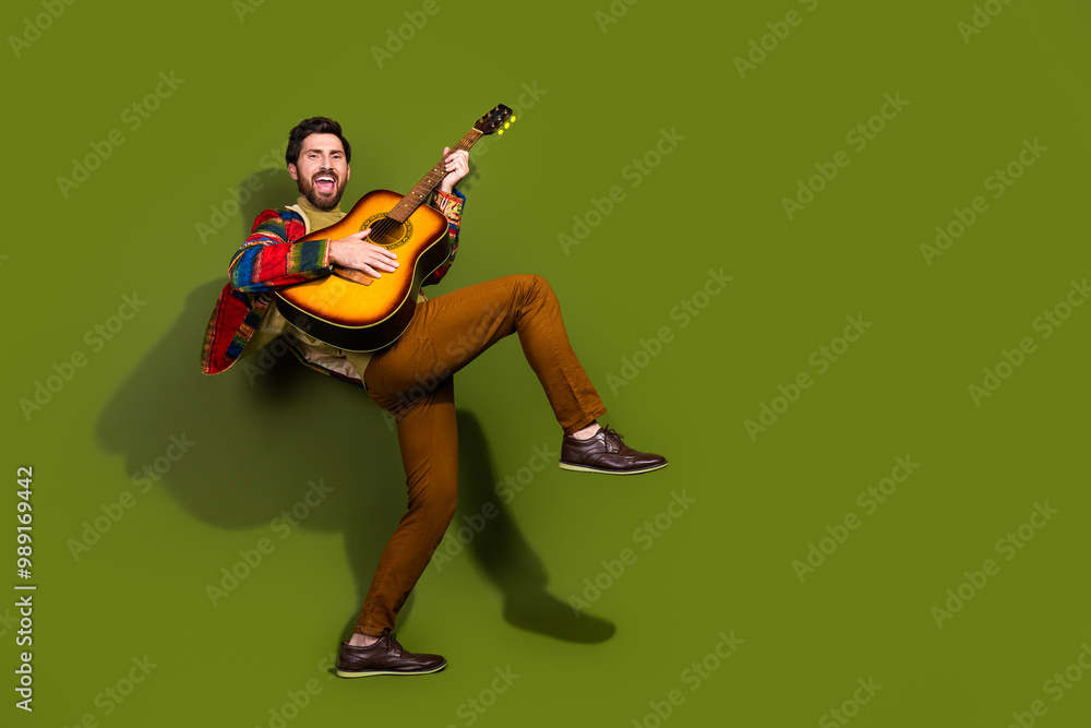 Fototapeta premium Photo of cheerful crazy man wear stylish clothes play guitar instrument isolated on khaki color background