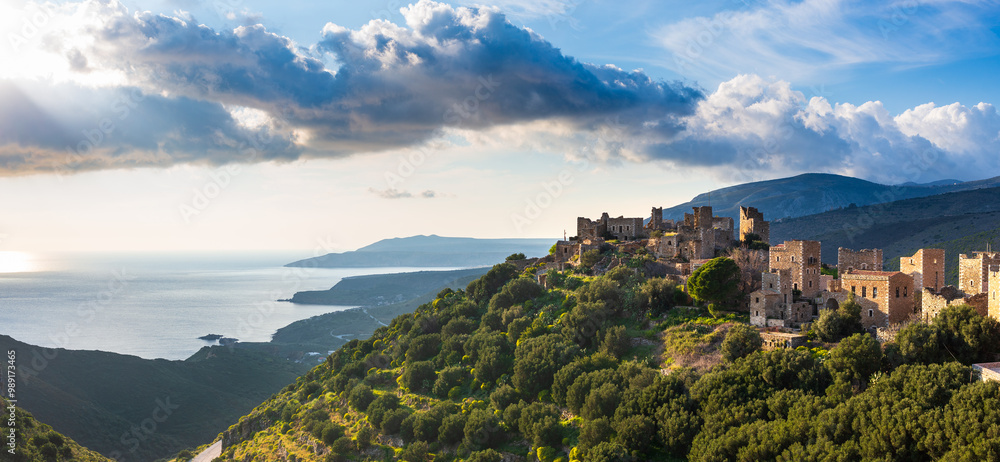 sunset illuminating the medieval village of vathia on the mani peninsula, greece. The sun setting over the mediterranean sea, illuminating the stone houses of hilltop medieval village