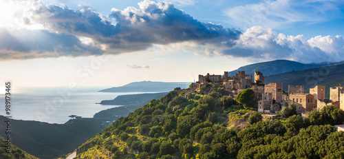 Obraz na płótnie sunset illuminating the medieval village of vathia on the mani peninsula, greece. The sun setting over the mediterranean sea, illuminating the stone houses of hilltop medieval village w salonie