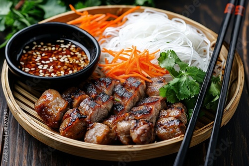 A fresh plate of Vietnamese bun cha with grilled pork, vermicelli noodles, fresh herbs, and dipping sauce, beautifully arranged on a bamboo tray photo