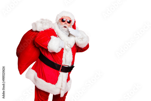 Photo of traditionally dressed amazed father hipster making noise while coming sneaking into house home at midnight noel holding hand near face large sack on back isolated vivid background copyspace