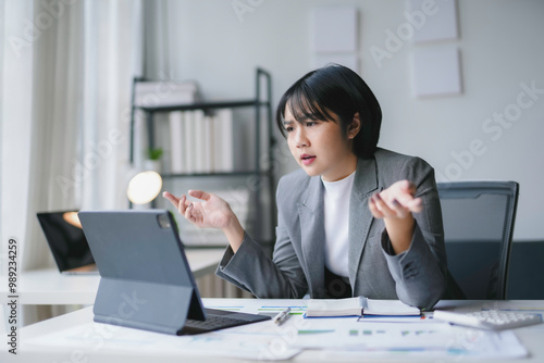 Φωτογραφία Young asian businesswoman is gesturing with hands while having a stressful video