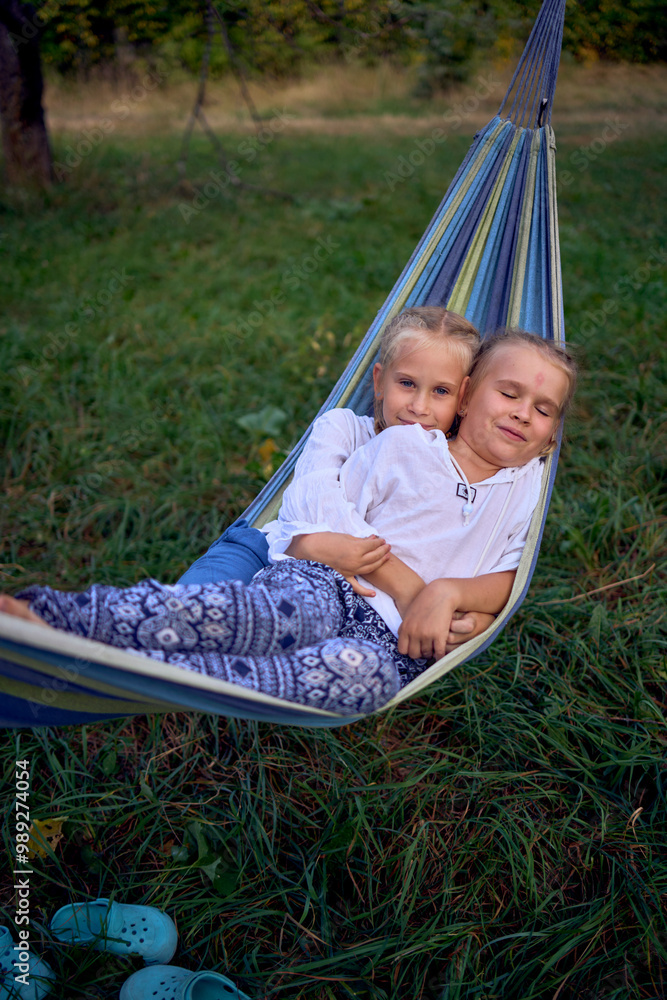 little sisters girls playing together in a hammock, camping with the children little sisters girls playing together in a hammock, camping with the children