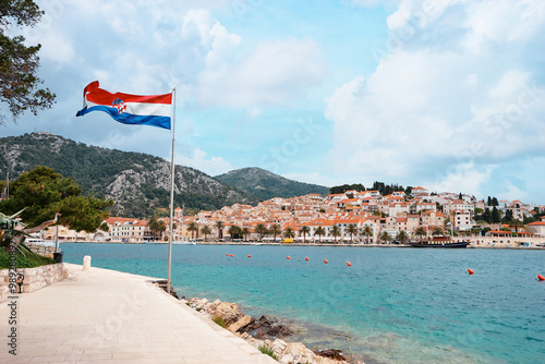 National croatian flag on Hvar's promenade. Beautiful landscape postcard with old town marine lagoon.