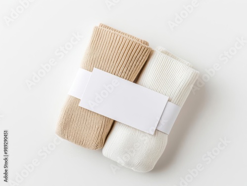 Highangle view of neatly folded socks with a blank label wrapped around, isolated on a clean white background, socks mockup with label, product packaging photo