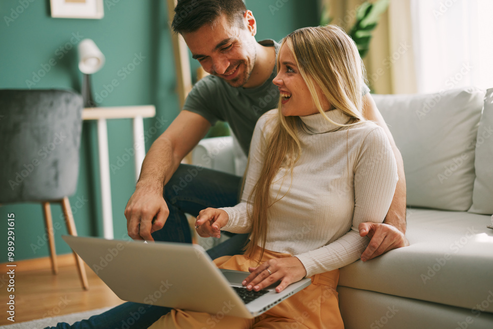 Young happy couple shopping via laptop online at home Young happy couple shopping via laptop online at home