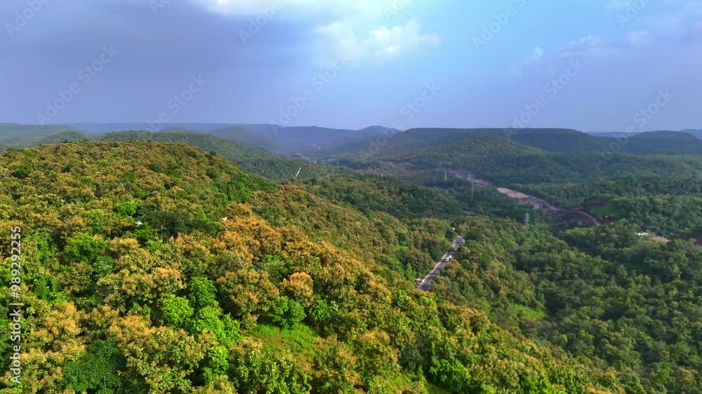 The roads are visible from the dense forest on the valley, curving through the green landscape. The roads are visible from the dense forest on the valley, curving through the green landscape.