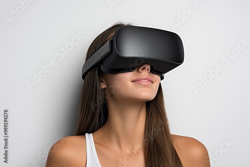 Immersive VR Experience Enchanting Woman in Virtual Reality Headset, Softly Smiling Against White Wall - Technology Concept