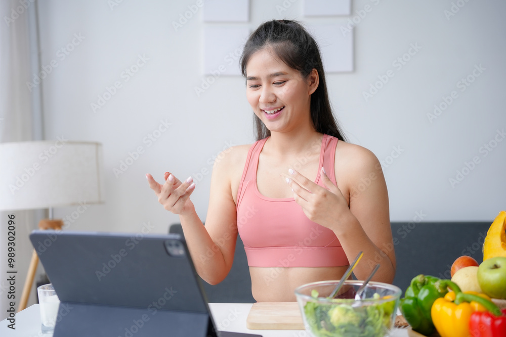 Smiling asian nutritionist in sportswear talking on a video call about healthy food, giving online fitness and diet advice Smiling asian nutritionist in sportswear talking on a video call about healthy food, giving online fitness and diet advice
